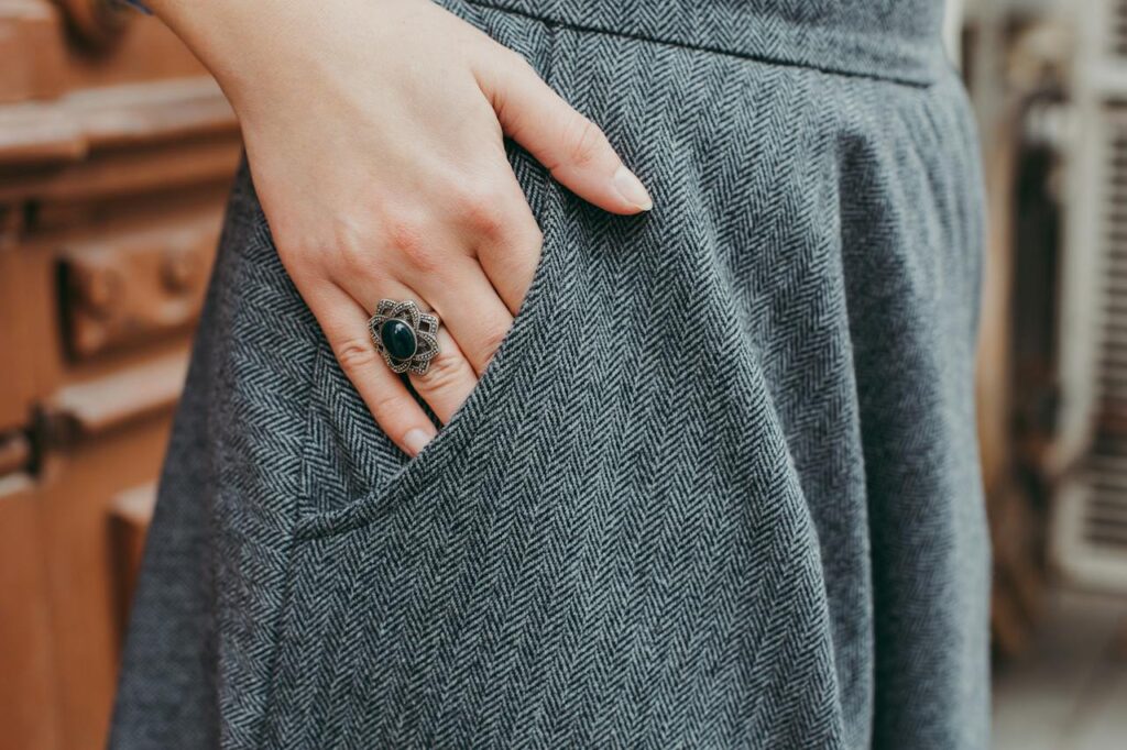 Ženská ruka v kapse dámských kalhot.