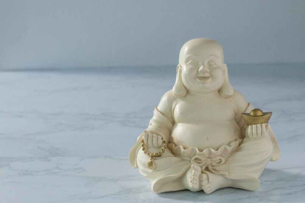 Bílá soška smějícího se Buddhy.