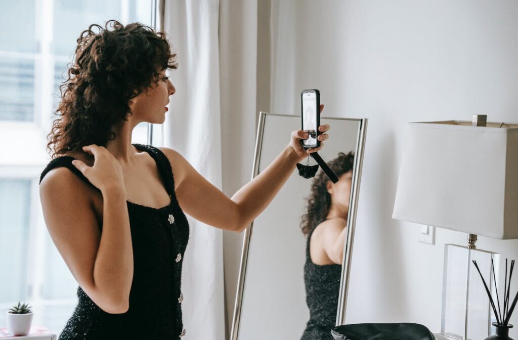 Žena v jednoduchých šatech dělající si selfie.