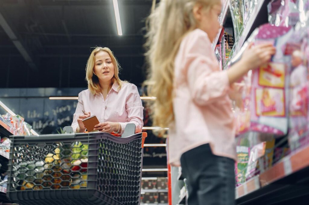 Matka nakupující s dcerou v supermarketu.