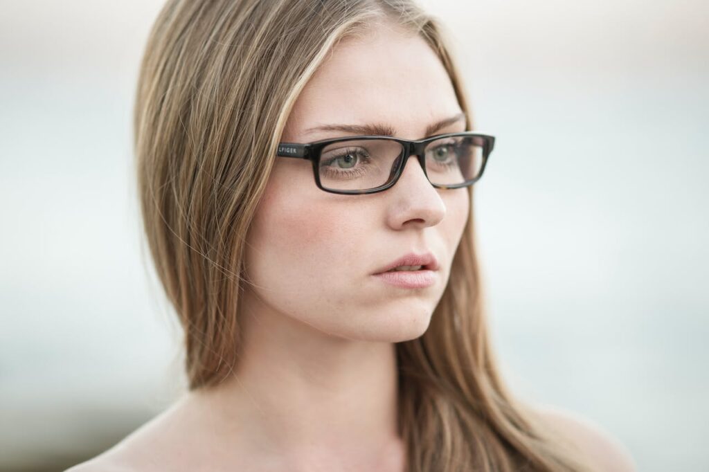 Dívka s dlouhými vlasy podél obličeje v brýlích.