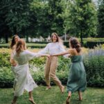 Ženy tančící v kruhu na zahradě.