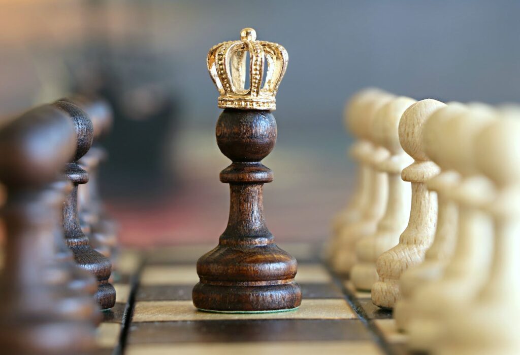 Detail na šachovou figurku se zlatou korunou.