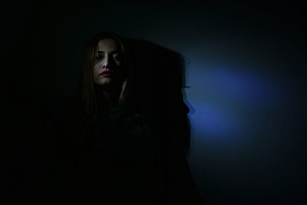 Dívka stojící ve tmě.
