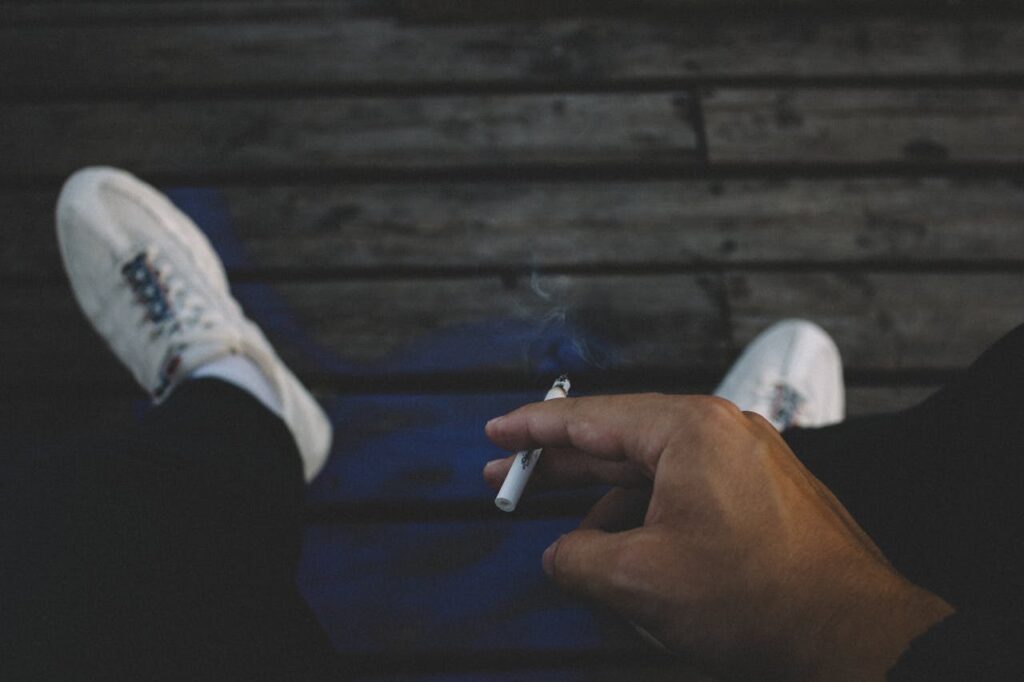Detail na pánskou ruku držící cigaretu.