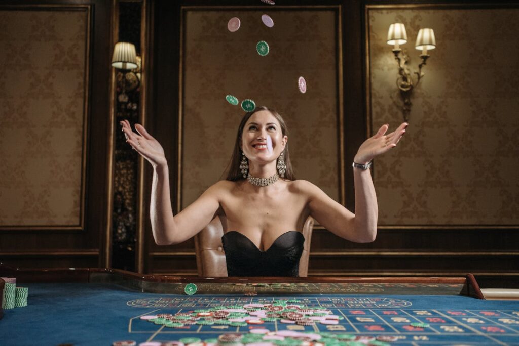 Žena vyhazující žetony sedící za stolem v kasinu. 