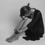 woman in black dress sitting on floor